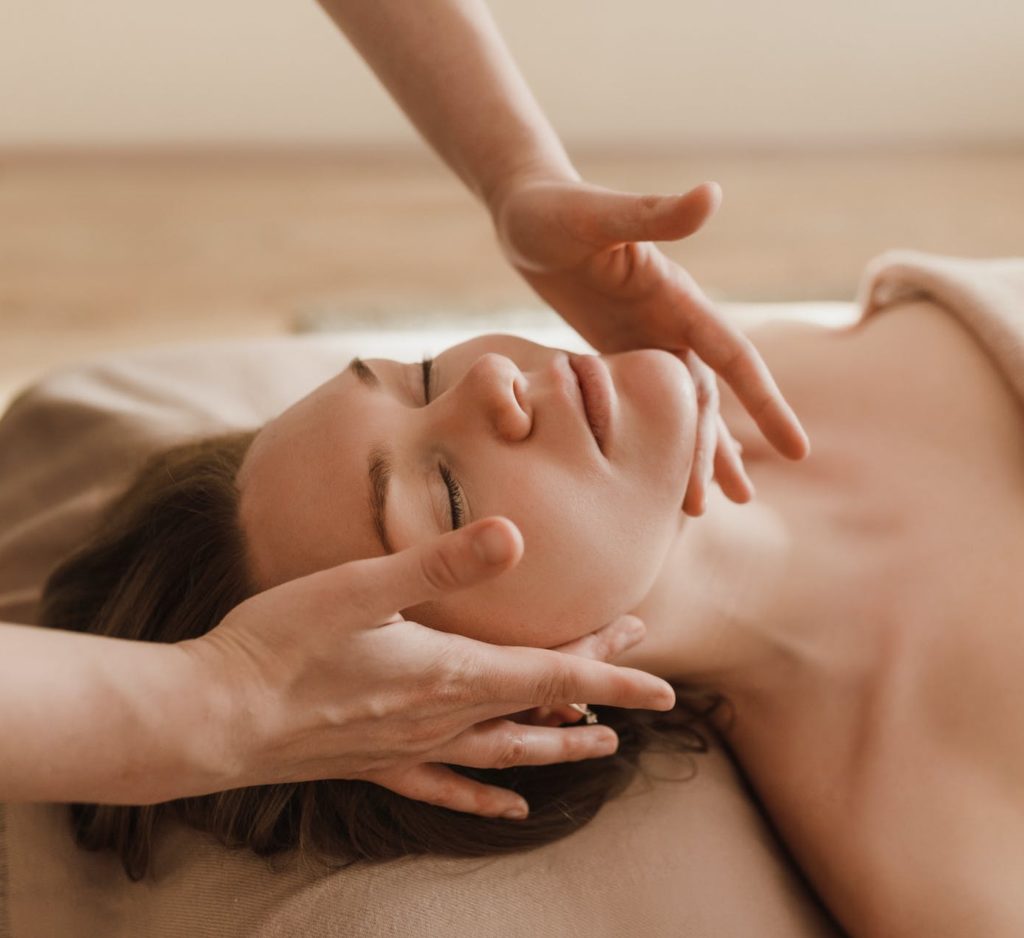 personne alongée recevant un soin du visage et se relaxant